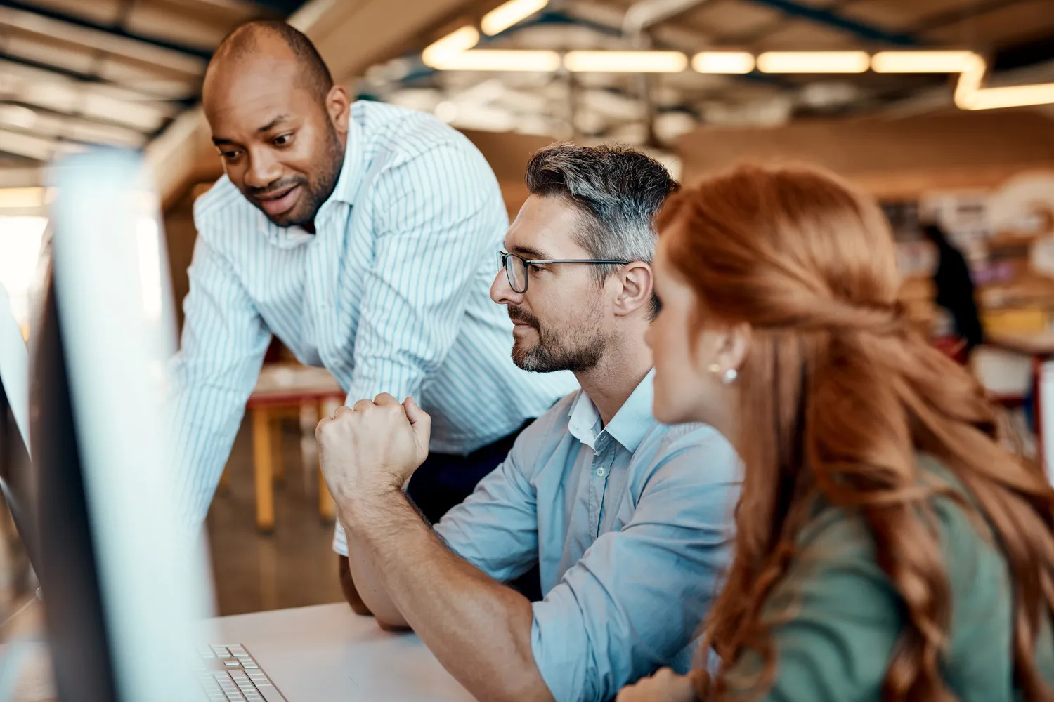 Travail à 3 personnes derrière un ordinateur